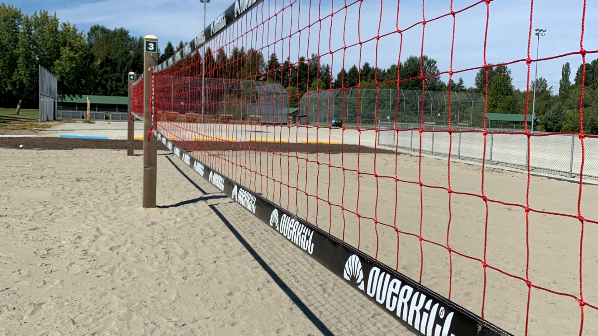 A close up of a volleyball next on a sandy beach