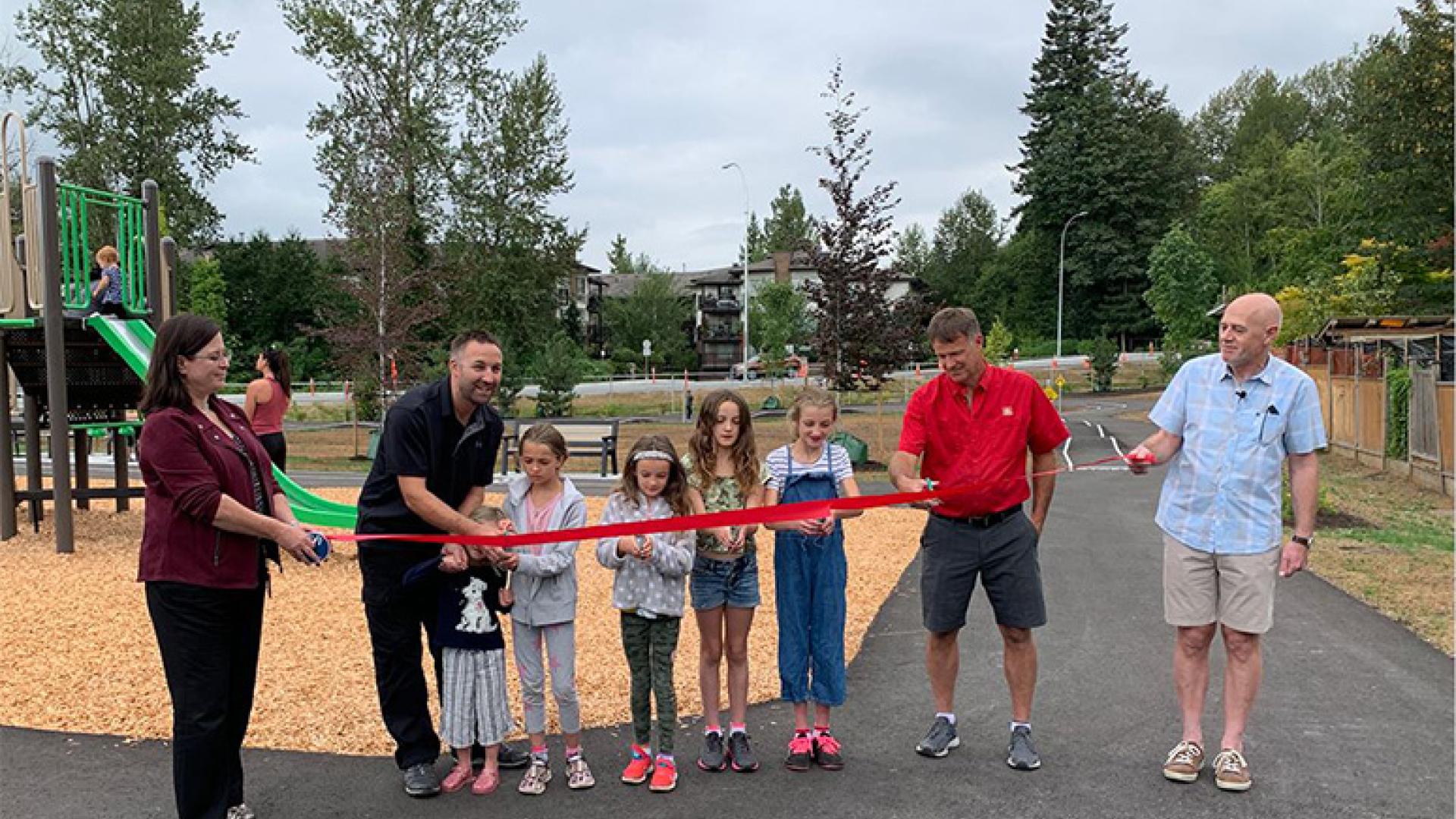 People outside of park cutting ribbon