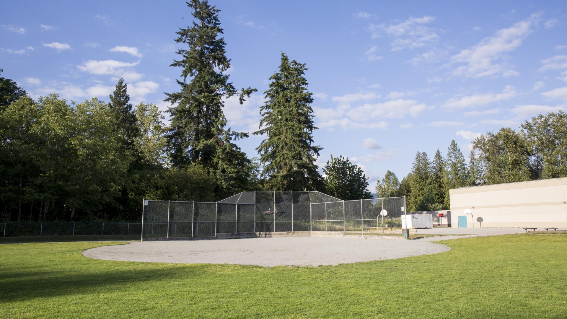 A large gravel sports area sits in the middle of a field.