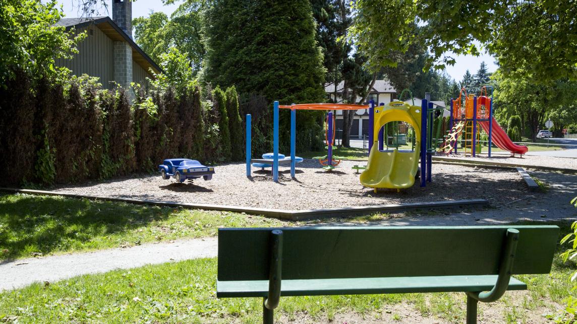 A green bench overlooks the playground.