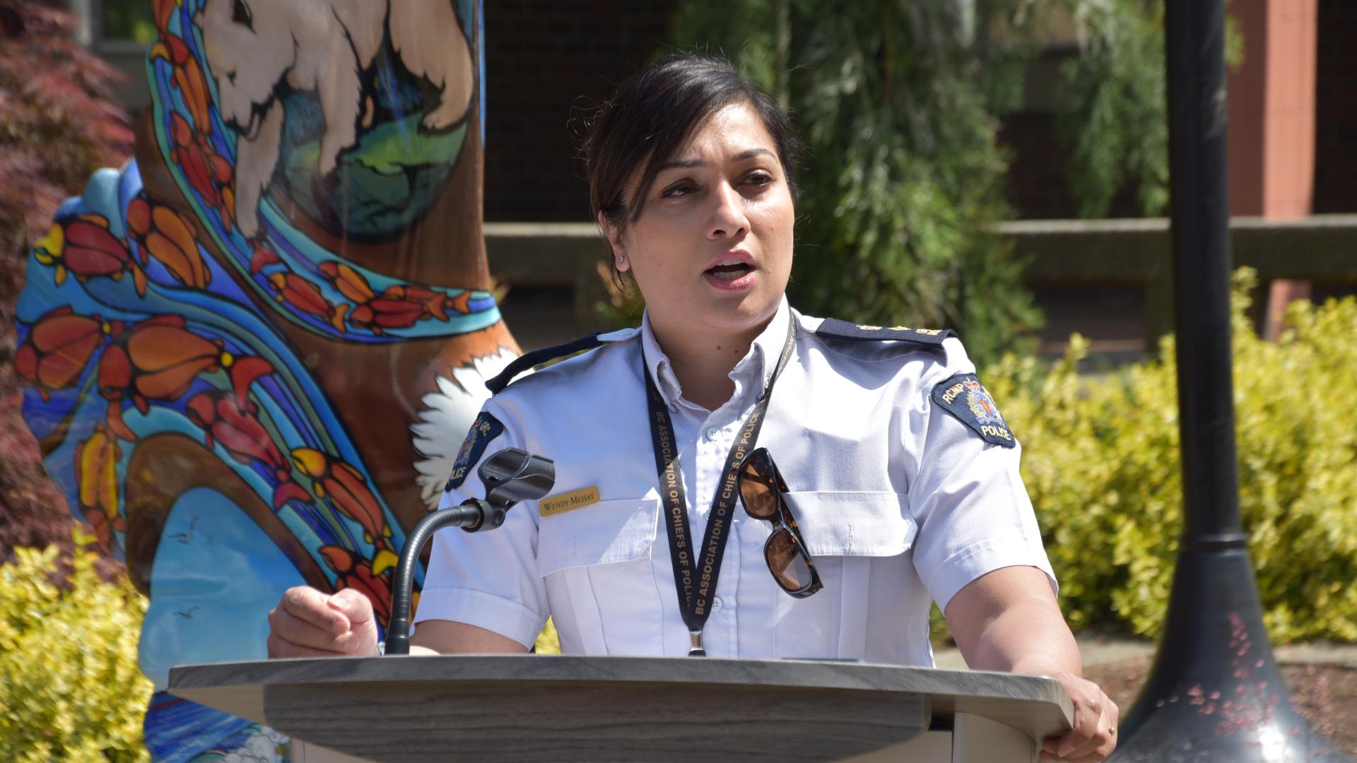 Police woman on a stand speaking to a crowd at the Law Enforcement Torch Run