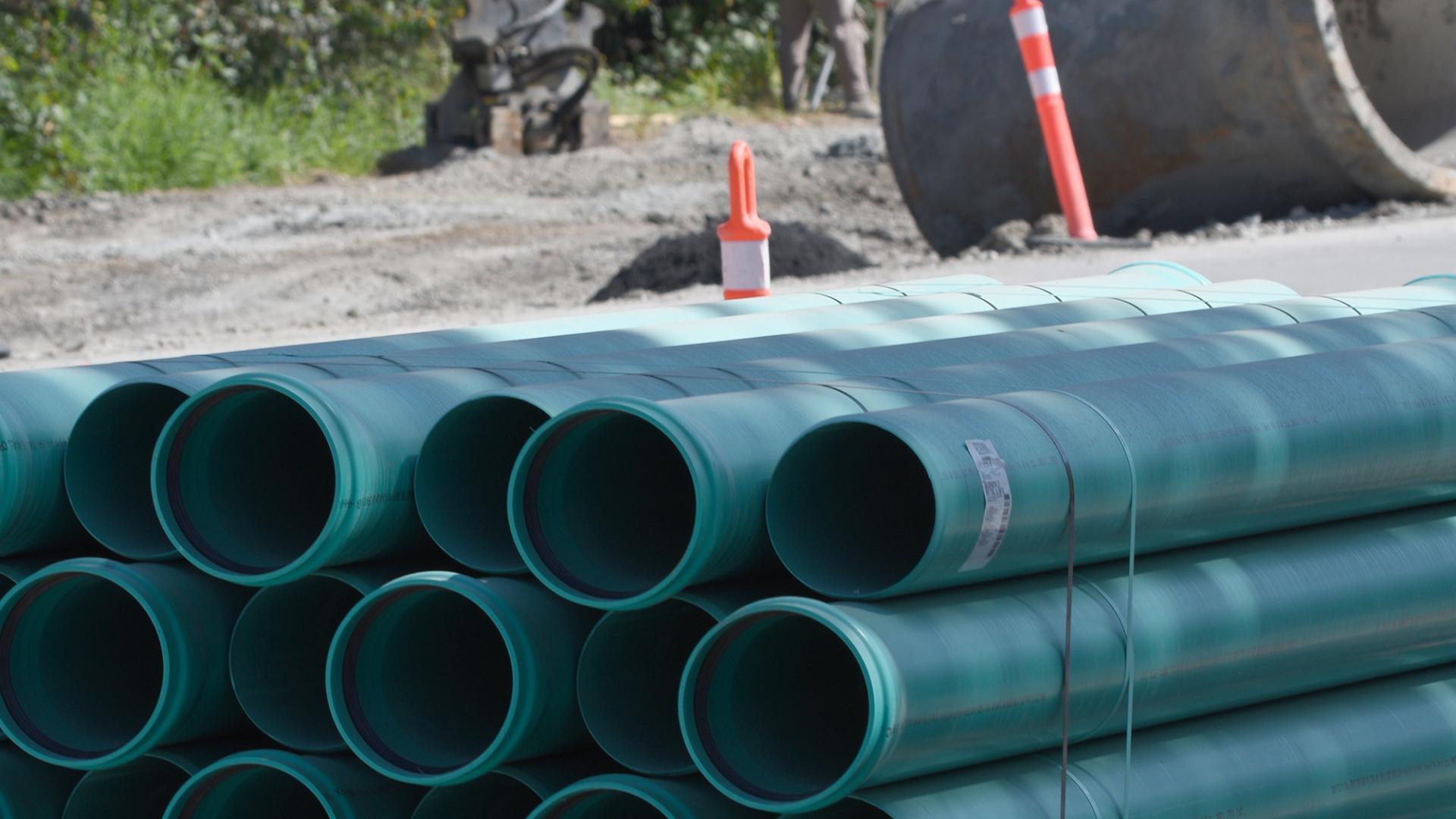 A pile of pipes waiting to be laid in the ground.
