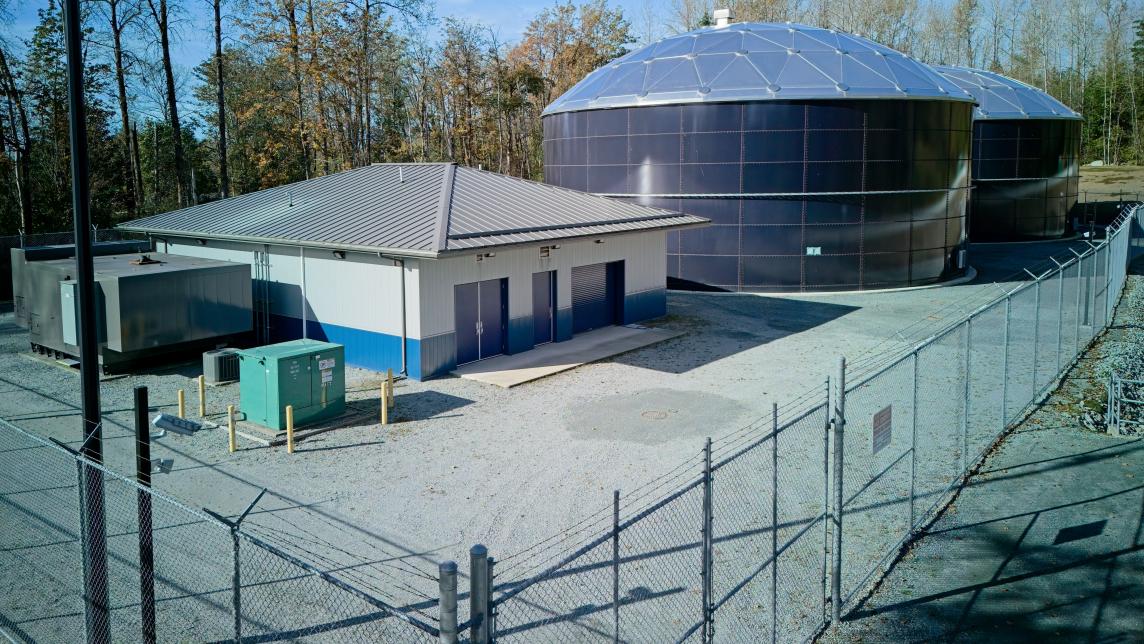 View of the pump station building and two tanks in the background