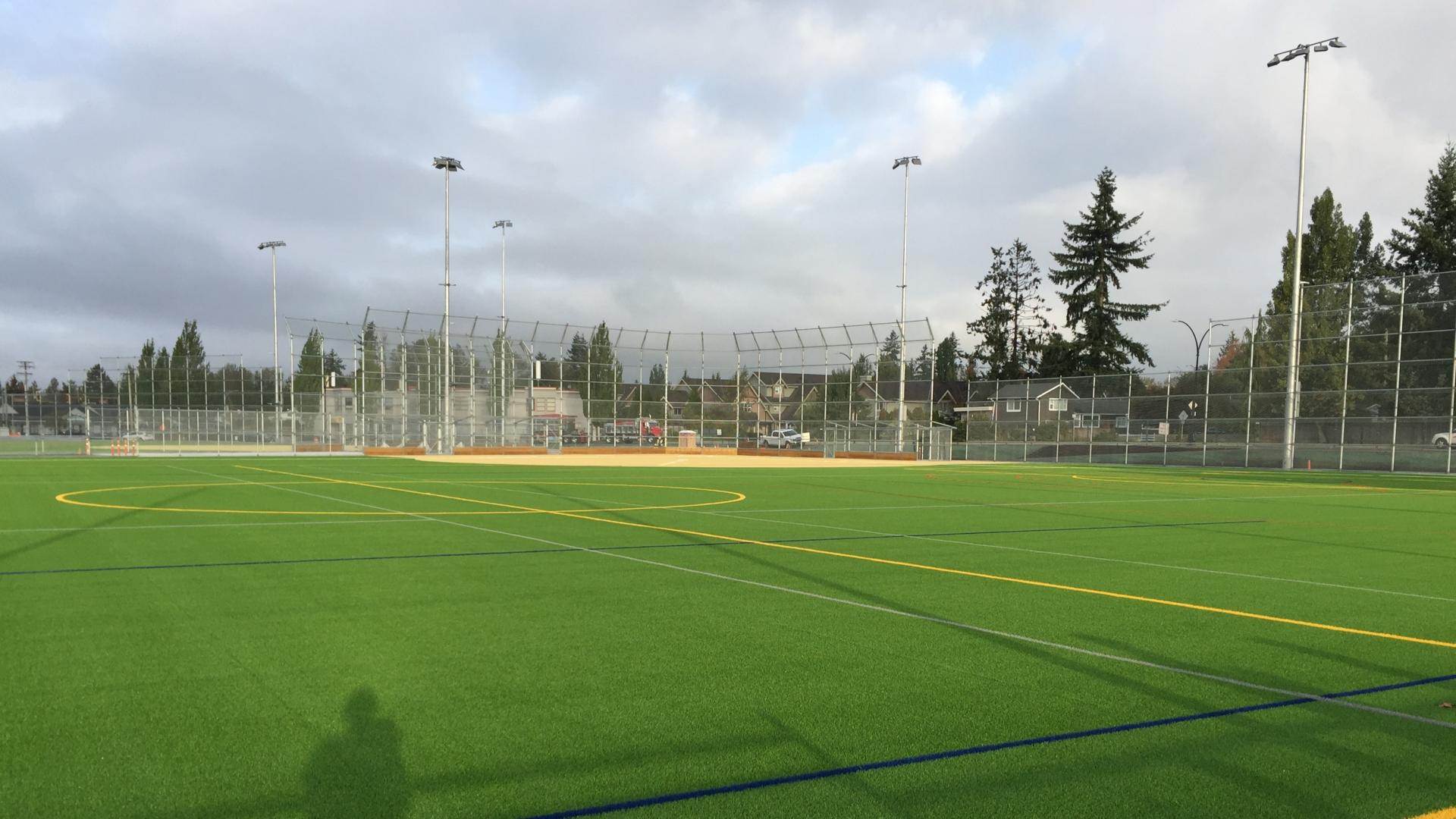 Synthetic sports field with tall chain link fence surrounding
