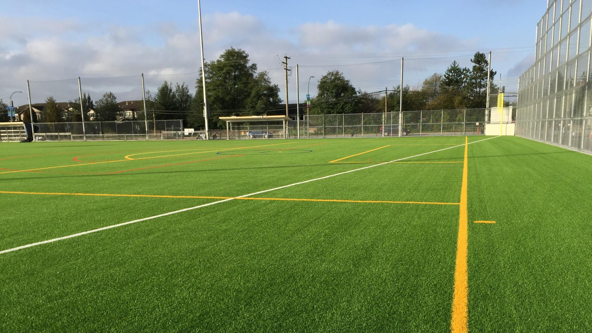 Synthetic sports field with tall chain link fence surrounding