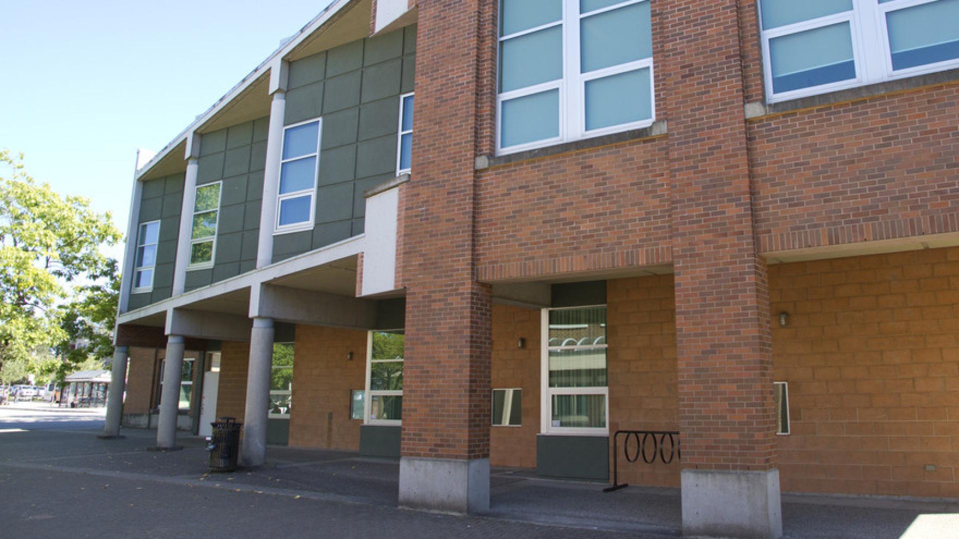 A large brick two-story building housing Bylaws stands tall over the sidewalk.