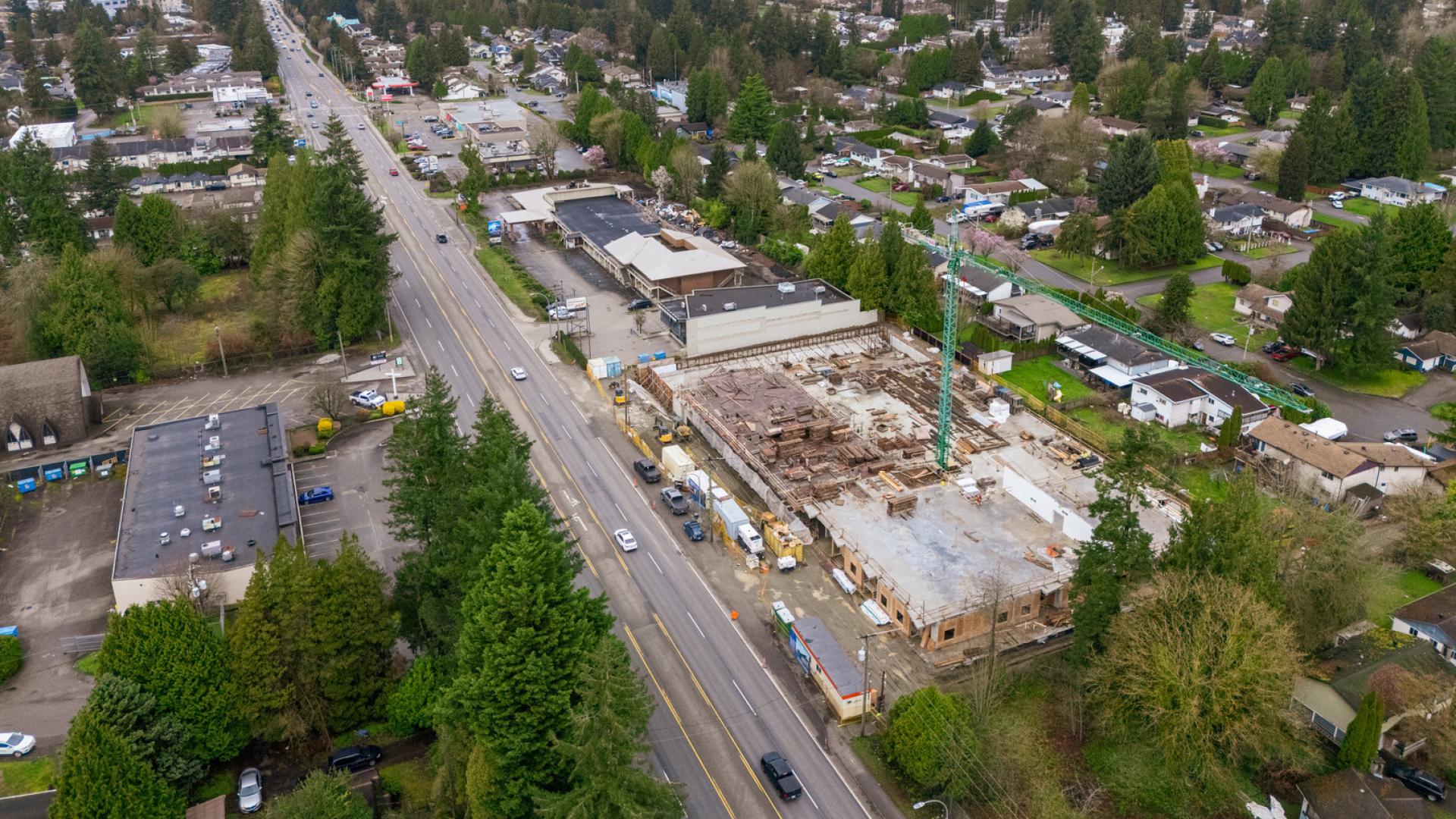 Cars on Lougheed highway travel next to an active construction site.