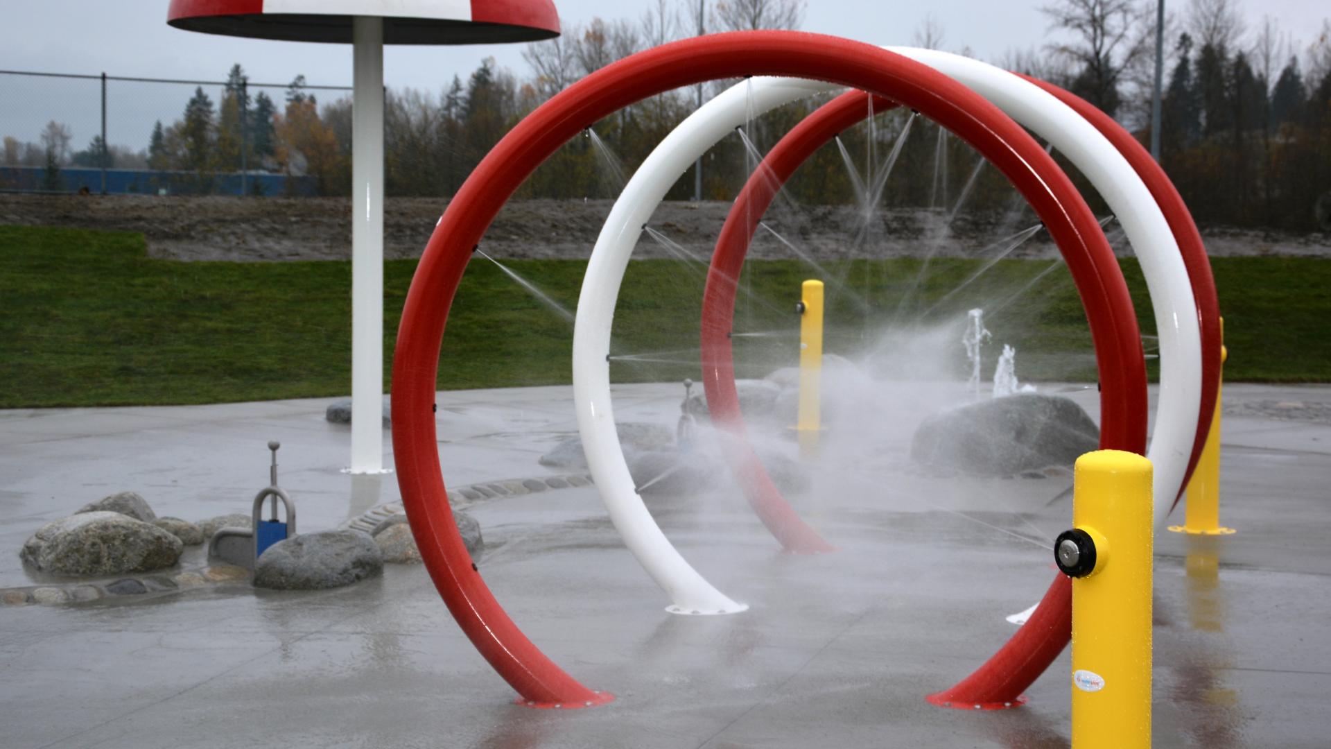 Red and white water-O's spraying water in a spray park