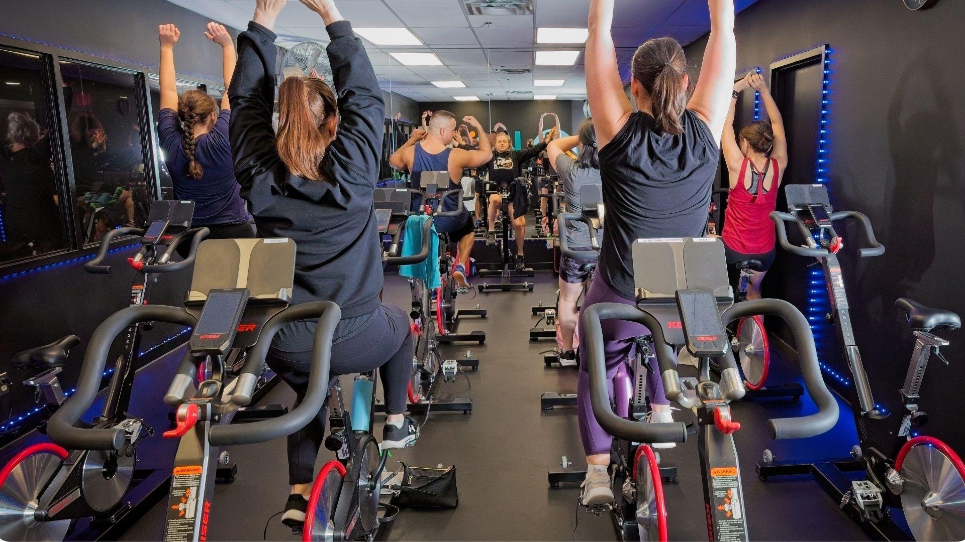 Group of people cycling indoors at a gym