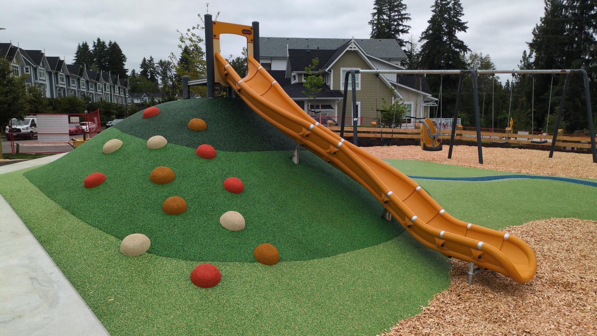 Tall yellow hill slide on green rubber mound
