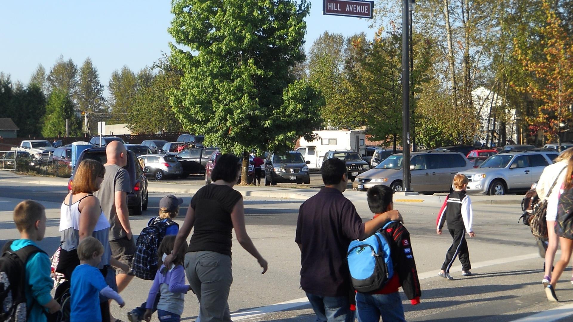 parents and children crossing in a crosswalk at Hill Ave