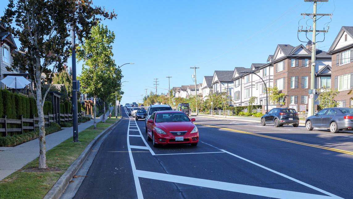 Cars parked next to a painted cycle lane