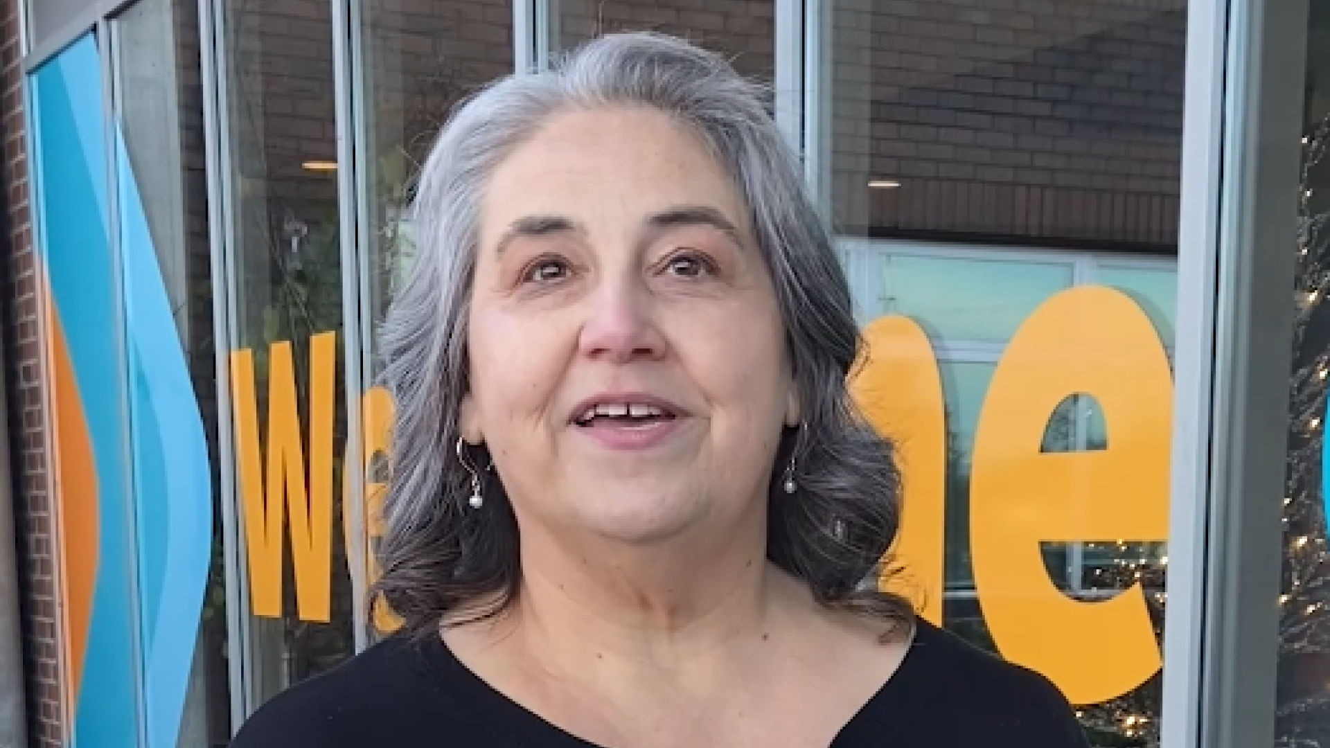 A woman stands in front of City Hall with the caption "You can get involved".