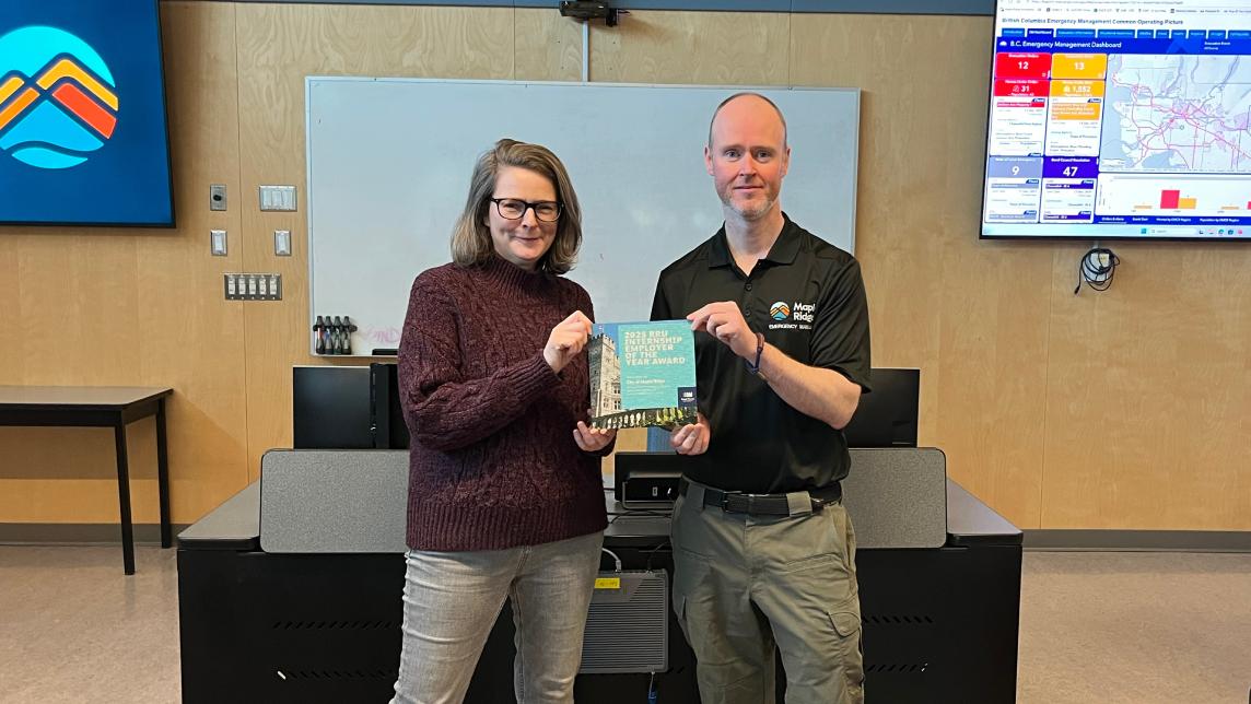 Maple Ridge being presented with certificate from Royal Roads in a classroom setting