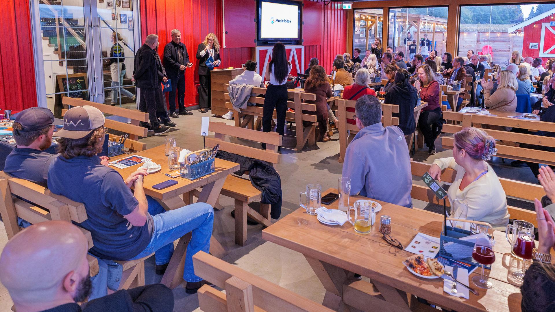 A crowd at the Patch Brewery watches presenters at the 2025 Innovation Challenge Awards event.