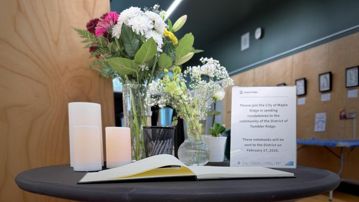 book of condolences with flowers and candles on a small table