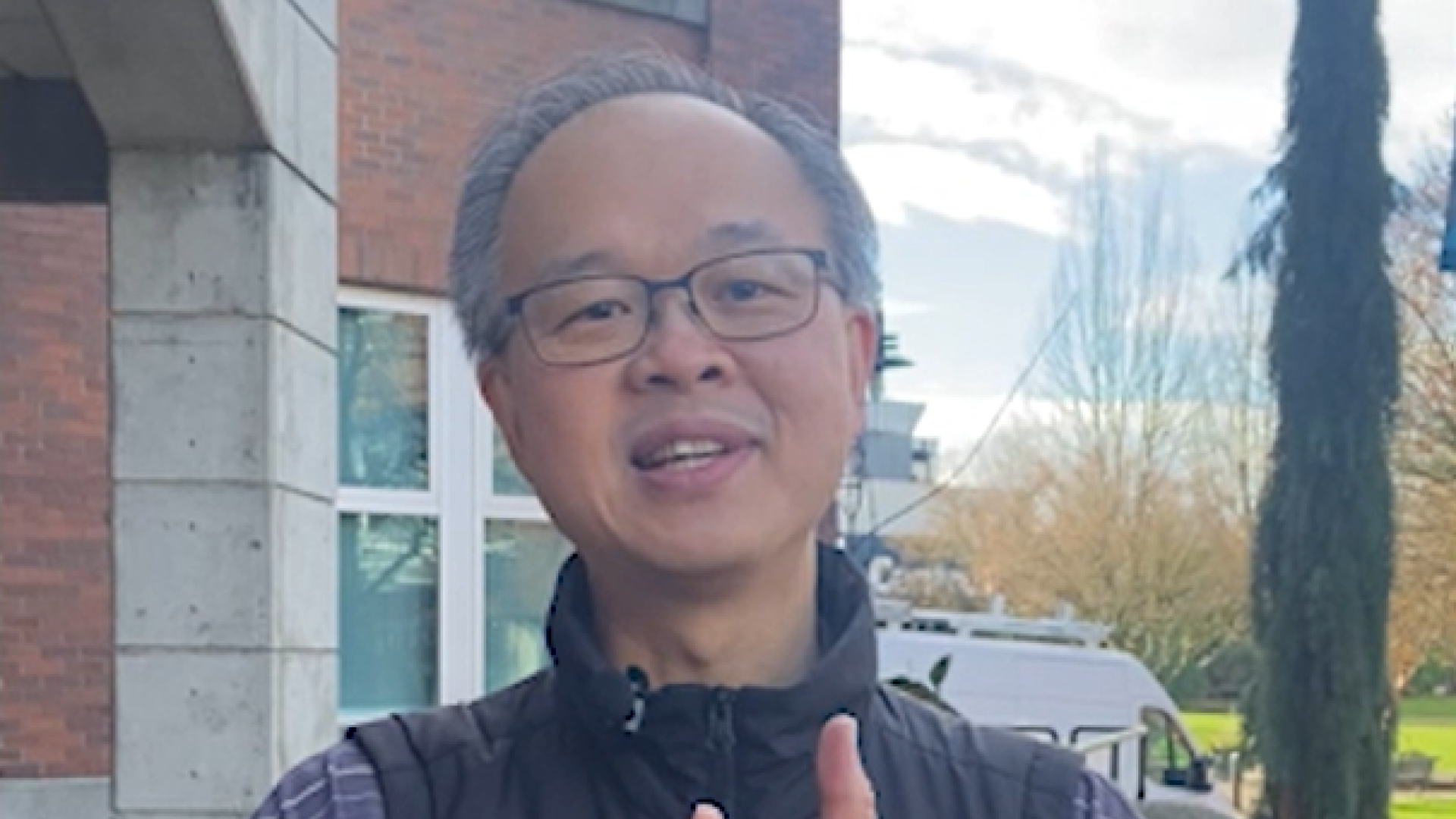 A man standing outside the Randy Herman Building counts talking points on his fingers.