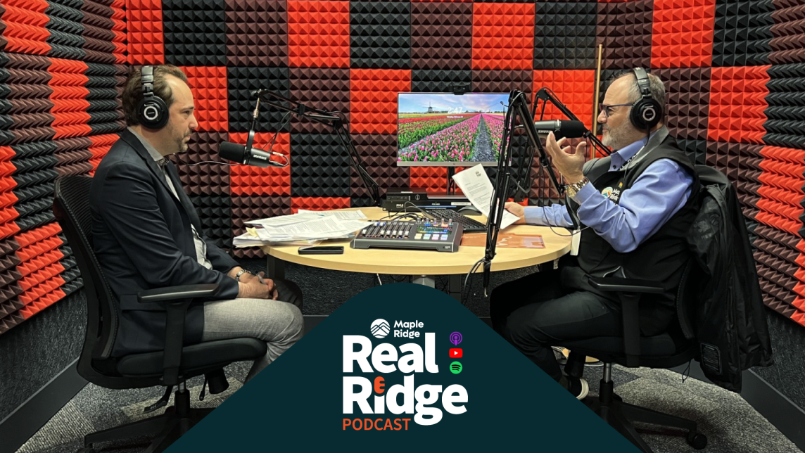 Mayor Dan Ruimy and Eric Aderneck sit at a table in a recording studio mid-conversation, discussing Industrial Lands.