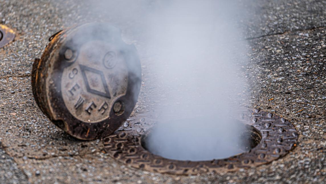 Fog emerges from an open sanitary sewer inspection chamber