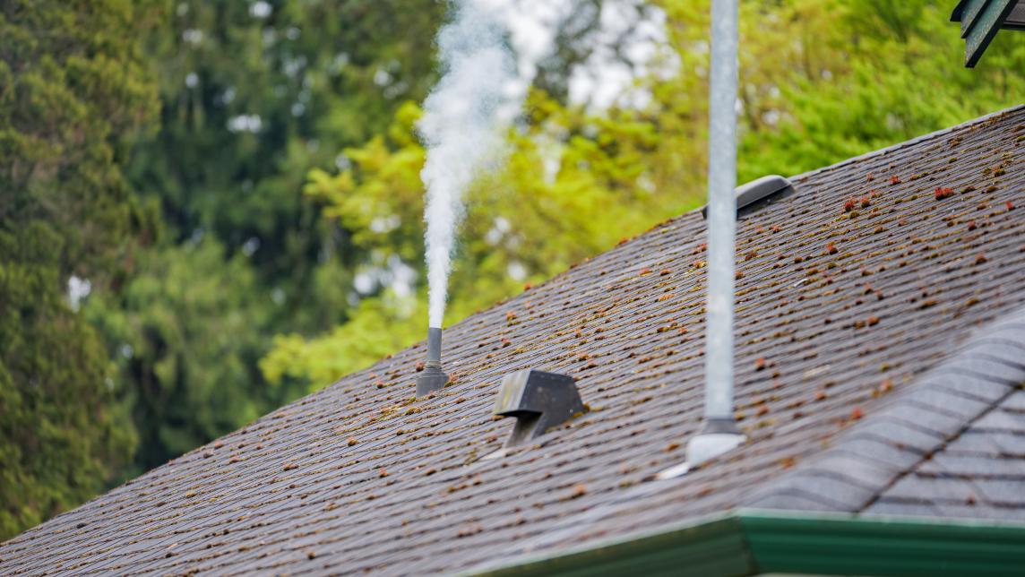 Fog emerges from a sanitary sewer vent stack on the roof of a house