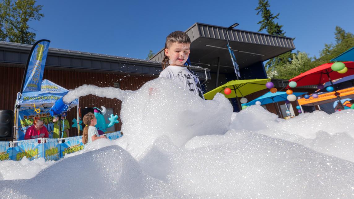A young boy plays in a large pile of bubbles at the Albion Community Centre during a Rock the Block event.