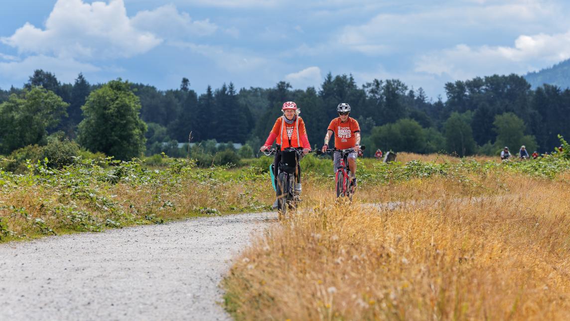 People biking along a dyke trail in Maple Ridge. 