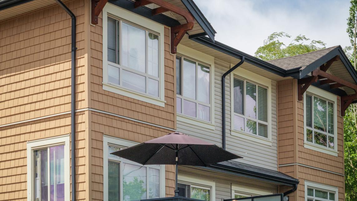 A completed fourplex residence with tan siding.