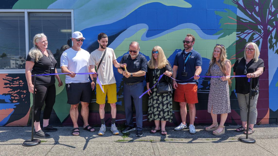 May Dan Ruimy and his council cut a blue ribbon with help from the artists to unveil the mural.