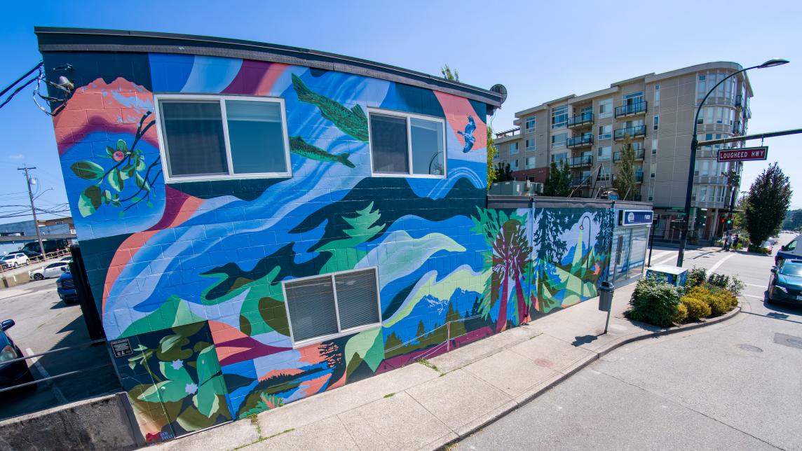 A view of the mural, looking towards Lougheed Highway. Salmon and red wave motifs swim throughout the design.