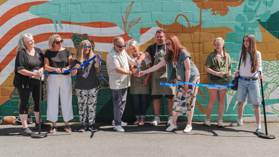Mayor Dan Ruimy and his council cut a blue ribbon with help from the mural's artists.