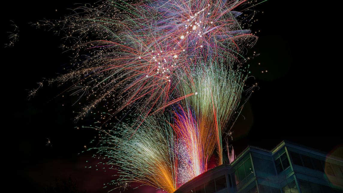 Colourful fireworks shoot upwards in streams from the roof of the Maple Ridge Business Centre tower and Library.