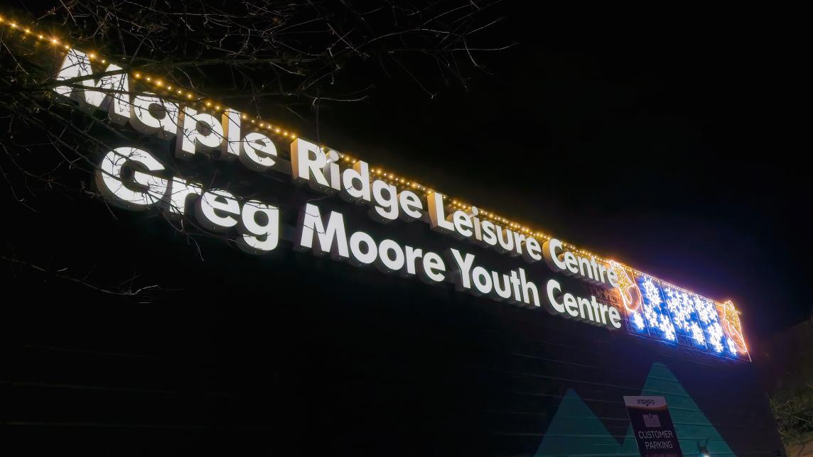 The illuminated Maple Ridge Leisure Centre and Greg Moore Youth Centre exterior signage, with temporary lights shaped like snowflakes.