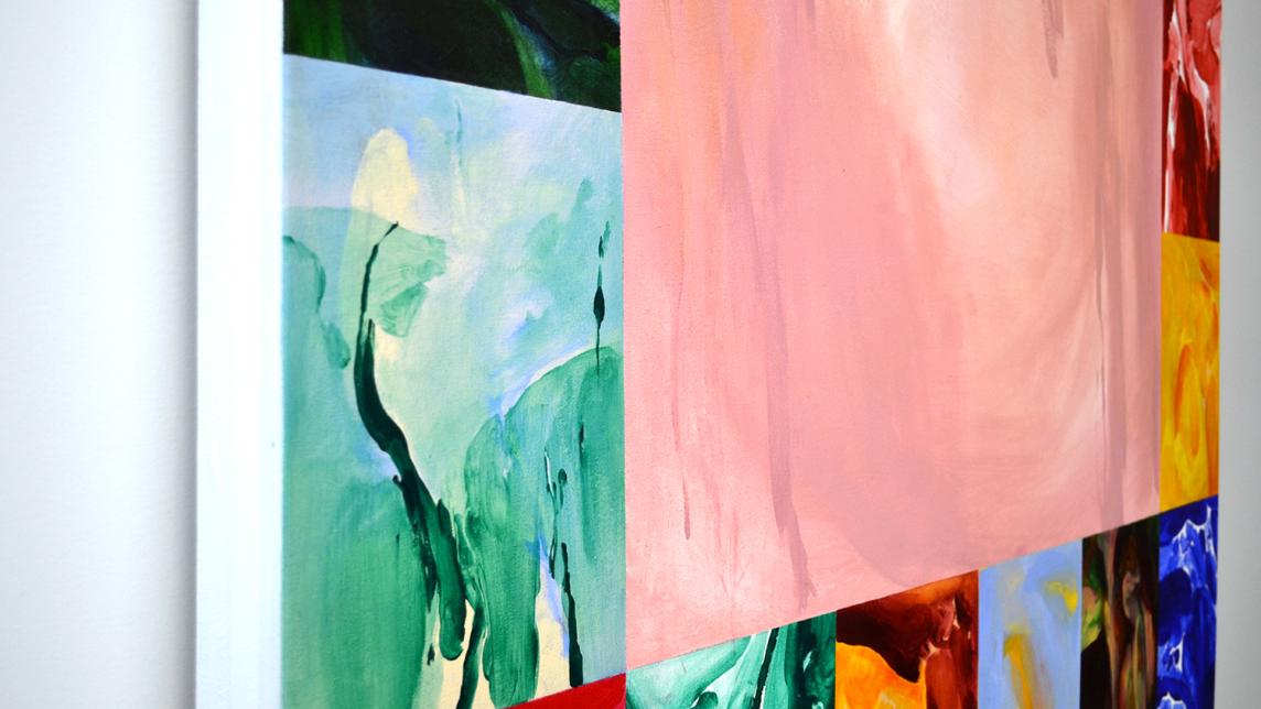 An angled view of a painted collage showing abstract art in vibrant colours.