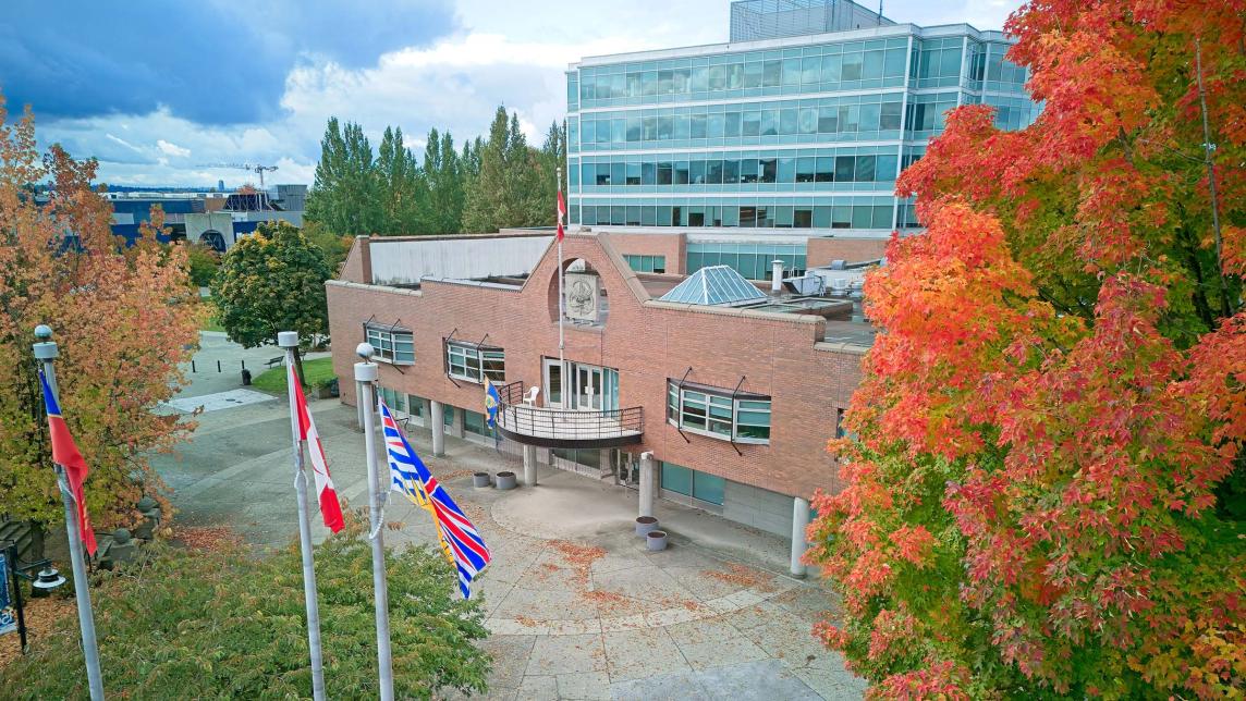 City Hall municipal building with red fall foliage in front right of image