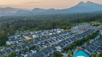 An aerial shot of houses with mountains in the background, above a teal background with black text reading "Mayor's statement on Federal Budget 2024".