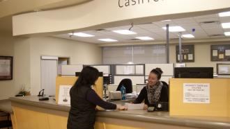 City staff member helping a customer at the cashier counter at City Hall