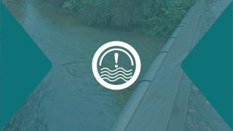 An exclamation point overtop a faded blue swollen river as seen from a bridge.