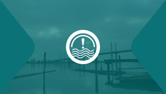 A white exclamation mark sits overtop the bank of the Fraser River.