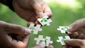 three pairs of hands holding puzzle pieces with different natural environment icons on them