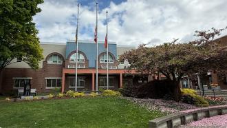 Three flags hang at half mast in from of the RCMP building at the edge of Spirit Square. 