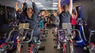 Group of people cycling indoors at a gym