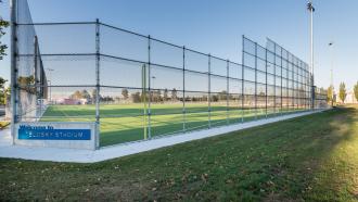 Telosky Stadium sits behind a welcome sign and tall chain link fence designed to keep balls and sports equipment from exiting the area of play.