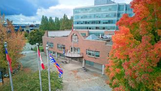 City Hall municipal building with red fall foliage in front right of image