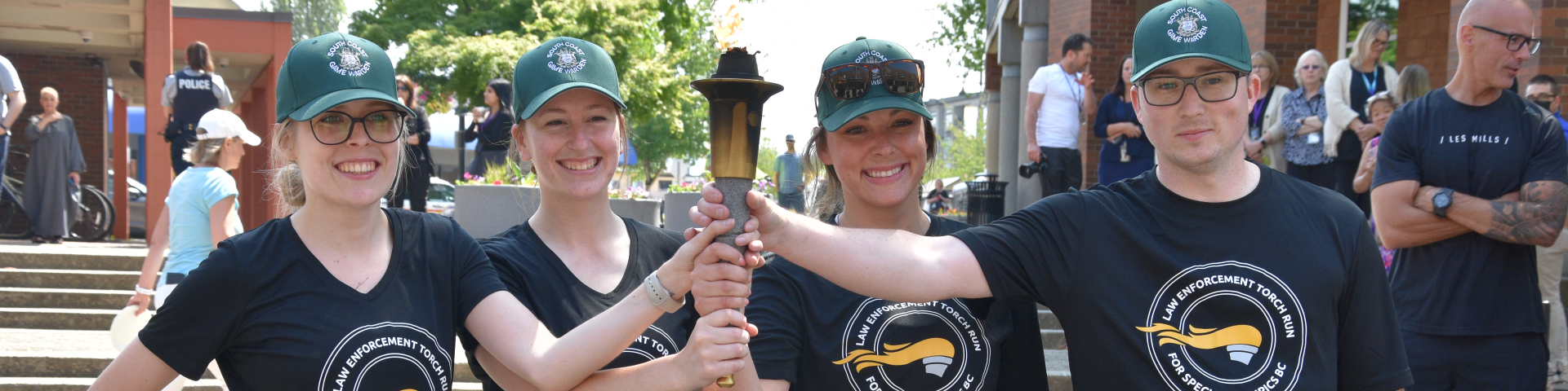 4 people holding up a touch after completing the Law Enforcement Torch Run
