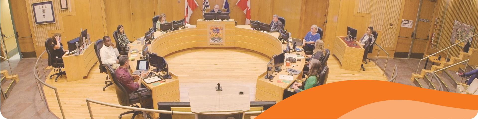 Maple Ridge's Council sits around a circular desk in Council Chambers at City Hall.
