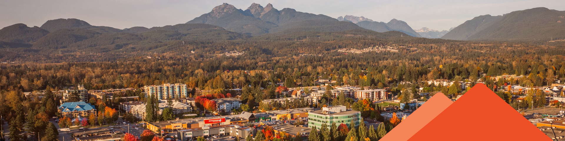 A high vantage point reveals the rooves of Maple Ridge's buildings as the Golden Ears looks on in the background.
