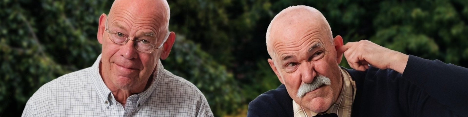 Two senior men sit side by side on a bench.