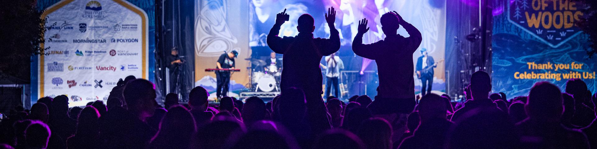 2 people on shoulders enjoying the stage performance
