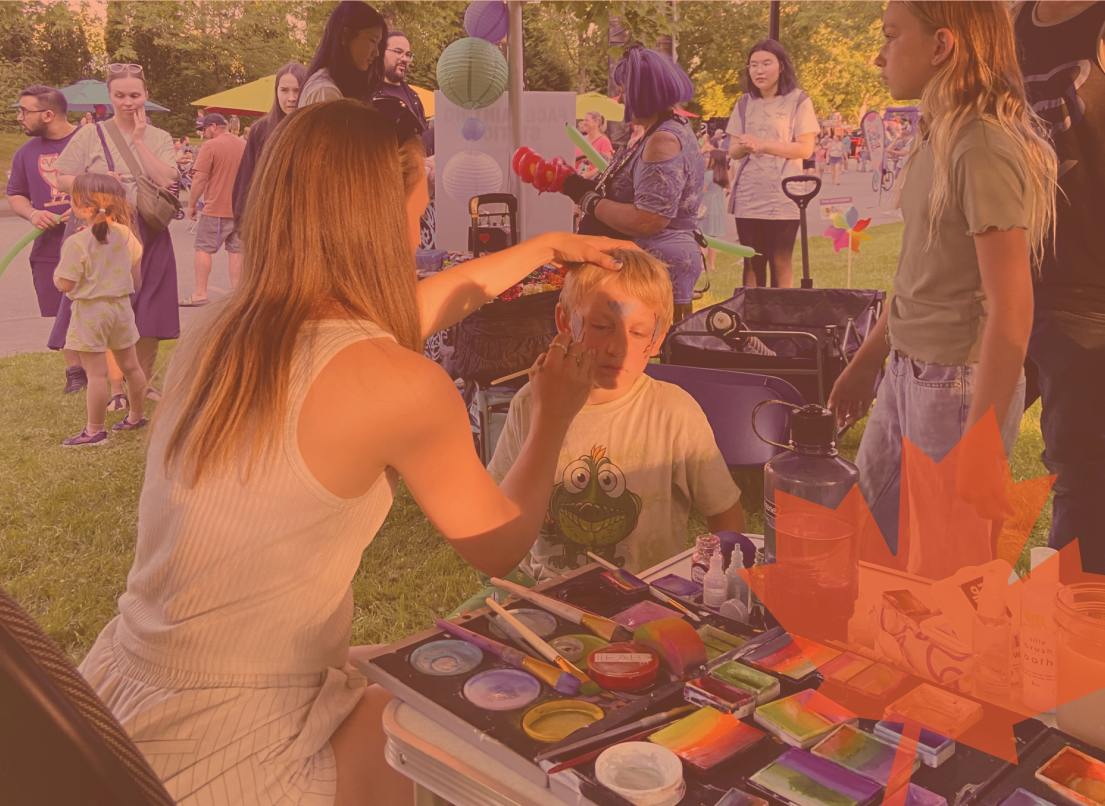 A Child Getting His Face Painted at Community Event