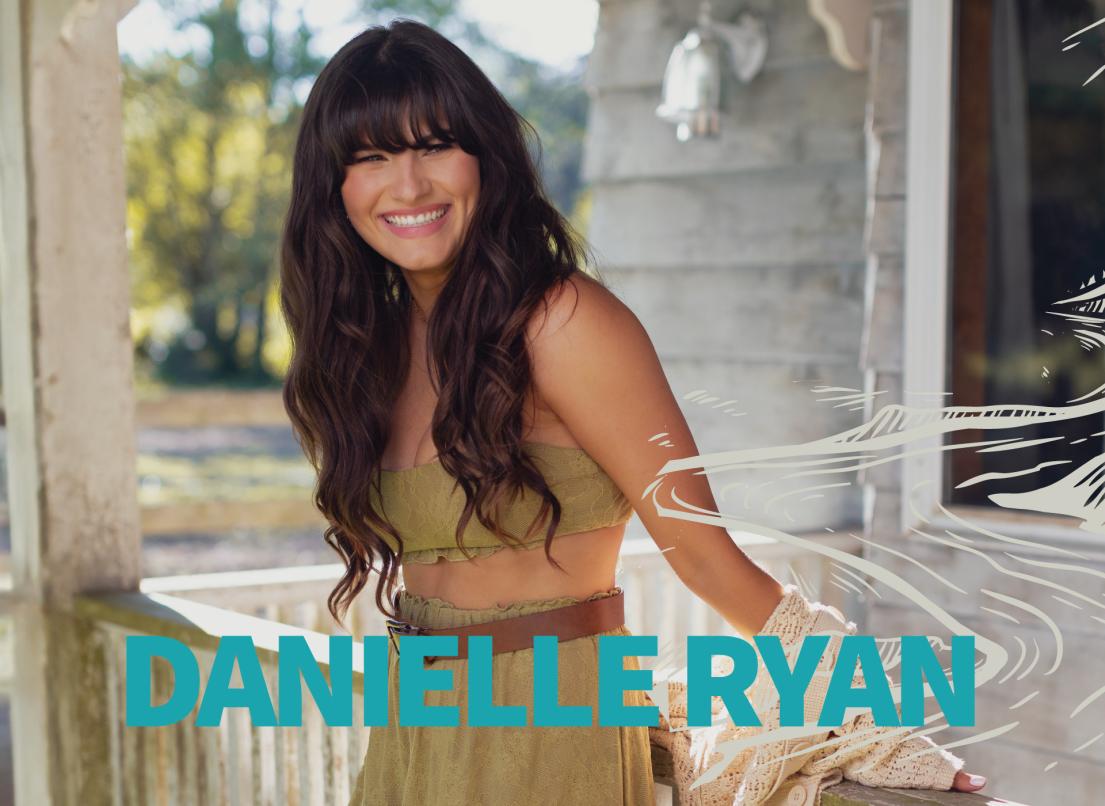 Danielle Ryan smiles as she stands on a white porch.